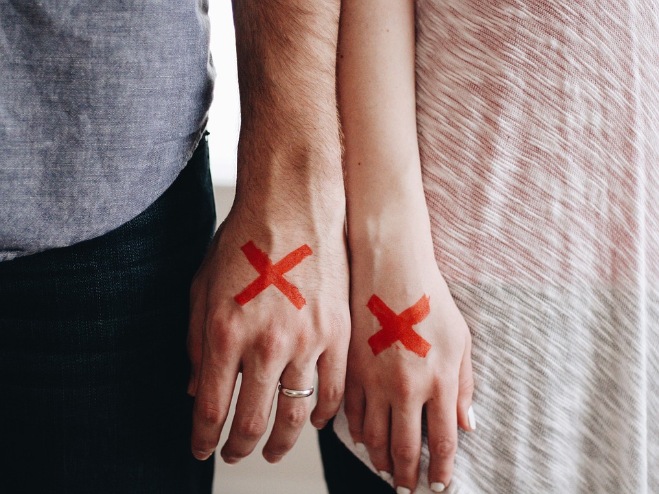 Couple with a red x mark on the hands